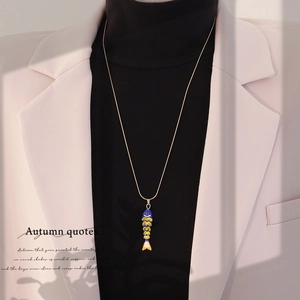Detail of vintage 3D articulated koi fish pendant in colorful enamel on a gold snake chain