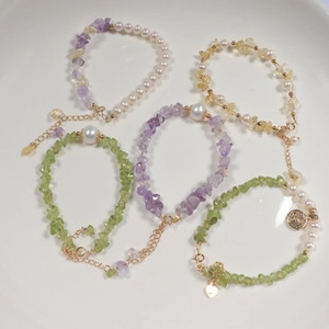 Macro shot of colorful stone beads and pearl bracelets with golden lobster clasps