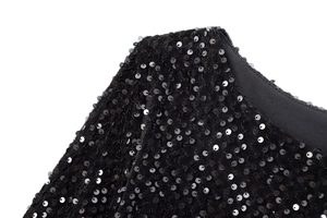 Détail de l'épaule d'une robe de soirée à manches longues avec sequins noirs