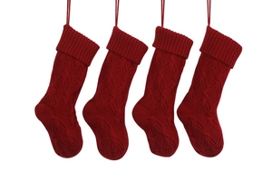 Detailed knit pattern on set of four red Christmas stockings for holiday decoration