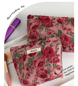 Dettaglio di beauty case rosa con motivi a rose rosse e texture ad alta densità
