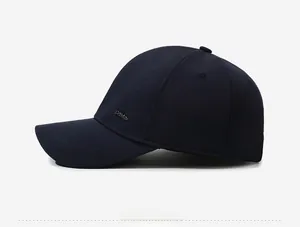 Detail of navy blue baseball cap showing Daria metal logo and textured fabric