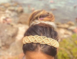Close-up of beige handmade bohemian woven headband with intricate braided cotton texture