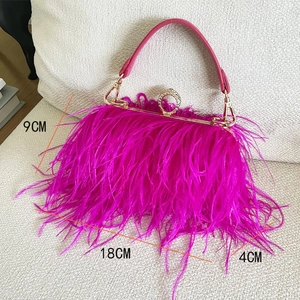 Macro detail of magenta ostrich feather handbag with large crystal ring clasp and gold trim