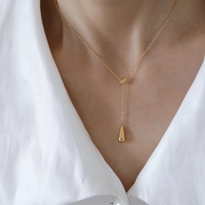 Elegant gold teardrop double pendant necklace on minimalist chain worn by a model
