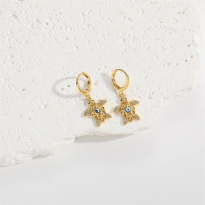 Minimalist golden sea turtle earrings with blue evil eye and white crystals