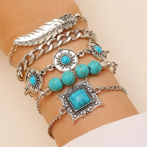 Close-up of bohemian five-piece bracelet set with turquoise beads and feather engraving