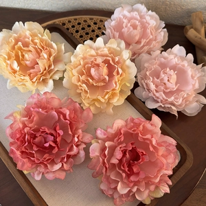 Detail of six colorful fabric peony hair clips in a rustic wooden tray for women