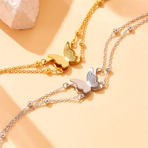 Double-layered gold and silver butterfly charm bracelets on stone decorative base