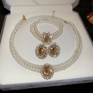 Detailed view of rhinestone pearl jewelry set with oval crystal necklace and earrings