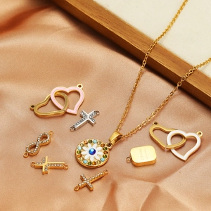 Golden stainless steel heart and cross charm necklace set on luxury silk background
