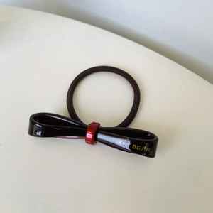 Elegant dark brown bow hair tie with red center and golden AMY BEAR print detail
