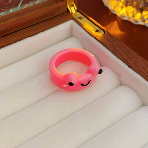 Close-up of cute bright pink frog resin ring in a velvet wooden jewelry gift box
