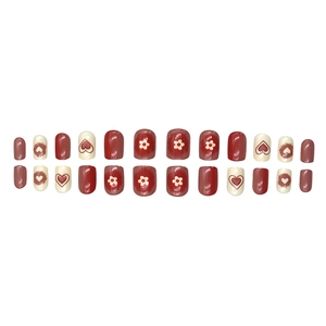 Deep red and cream white press-on nails with heart and daisy floral patterns