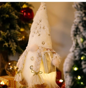 Close-up of glowing Christmas gnome with sequin hat and braids in warm holiday setting