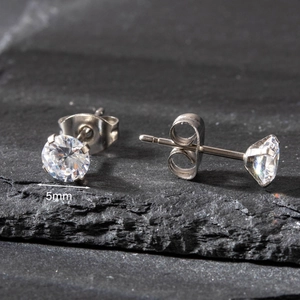 Macro detail of 5mm round clear zircon earrings with silver four-claw stainless steel setting