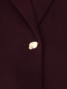 Makro-Detail des weinroten Blazers mit goldenem Metallknopf und feiner Köperstruktur