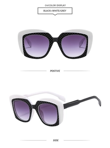 Close-up of oversized black and white checkered sunglasses with purple gradient lenses