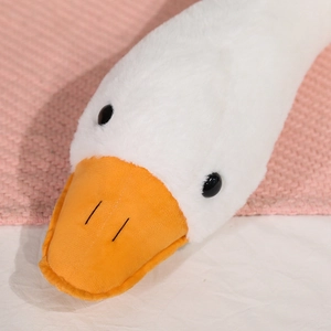 Close-up of the soft plush white goose head with orange beak and fuzzy texture
