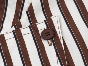 Macro detail of casual striped shirt featuring brown four-hole buttons and precise stitching