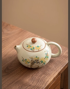 Detail of Ru kiln ceramic teapot featuring painted cat and yellow floral motifs