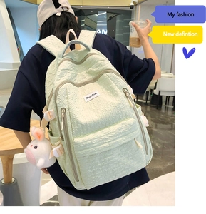 Détail du sac à dos matelassé vert menthe avec texture 3D et breloque lapin blanc mignon