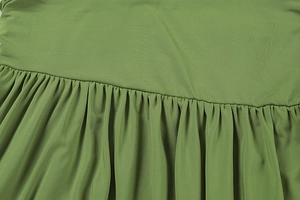 Detailed macro shot of olive green pleated fabric texture and stitching for resort dress