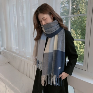 Detailed view of heavy plaid cashmere feel scarf with long tassels and navy blue accents