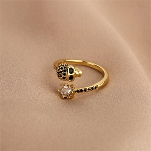 Macro shot of gold skull ring with black and white cubic zirconia on silk fabric