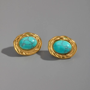 Détail de boucles d'oreilles dorées vintage avec turquoise ovale et dentelle ornée