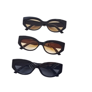 Three retro round cat eye sunglasses in black, tea and amber tints on white backdrop