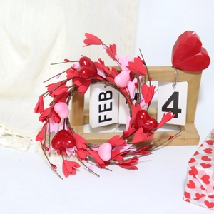 Gros plan d'une couronne de Saint-Valentin en forme de cœur avec bourgeons rouges et roses
