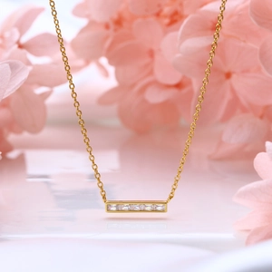 Macro shot of gold square pendant necklace with four sparkling white zircon stones