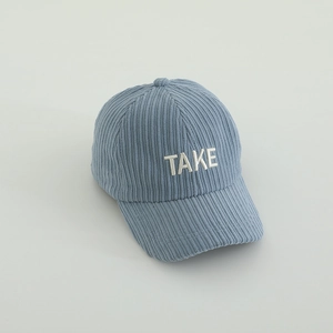 Détail de la texture en velours côtelé bleu et de la broderie TAKE sur la casquette enfant