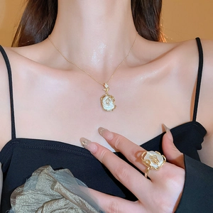 Détail d'un ensemble collier et bague en perles baroques dorées porté par un mannequin
