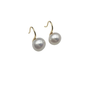 Elegant white freshwater pearl earrings with classic gold hooks on a plain background