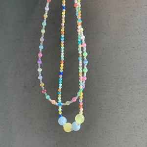 Close-up of rainbow seed beads and translucent cat eye stones on a summer necklace