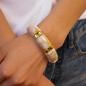 Macro detail of geometric acrylic marble beads and gold square spacers on bracelet