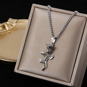 Detail of rose pendant necklace with vintage texture on champagne jewelry box