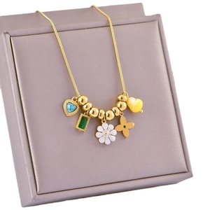 Golden necklace with floral and bee pendants on a lavender jewelry box display