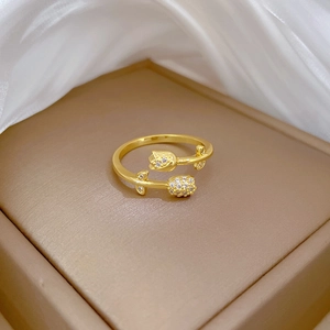 Elegant gold tulip ring with sparkling diamonds on a brown jewelry box with white silk