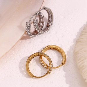 Close-up of gold and silver hoop earrings with double-row micro-pave crystals