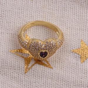 Détail d'une bague cœur en or avec pavé de diamants blancs et une pierre de zircon violette