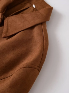 Detailaufnahme des braunen Wildleder-Cardigans mit feinen Nähten und matter Textur