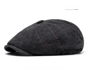 Detail view of dark grey herringbone wool newsboy cap with orange grid pattern