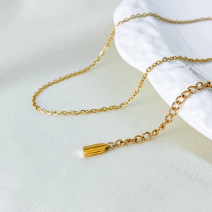 Close-up of a delicate gold-plated titanium steel chain necklace with an extender.