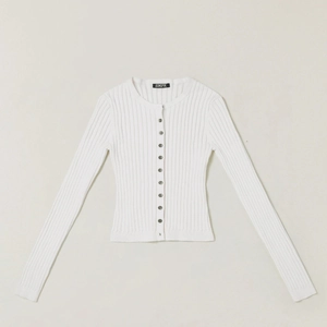 Detail of white ribbed knit cardigan with button closure and black neck label