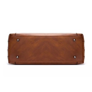 Bottom view of brown leather tote bag with protective metal feet and fine stitching