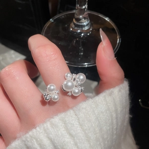 Detail shot of the vintage zircon and pearl open ring on model hand with knit sweater