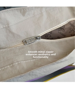 Détail de la fermeture éclair en argent et doublure logo de ce sac cabas en toile